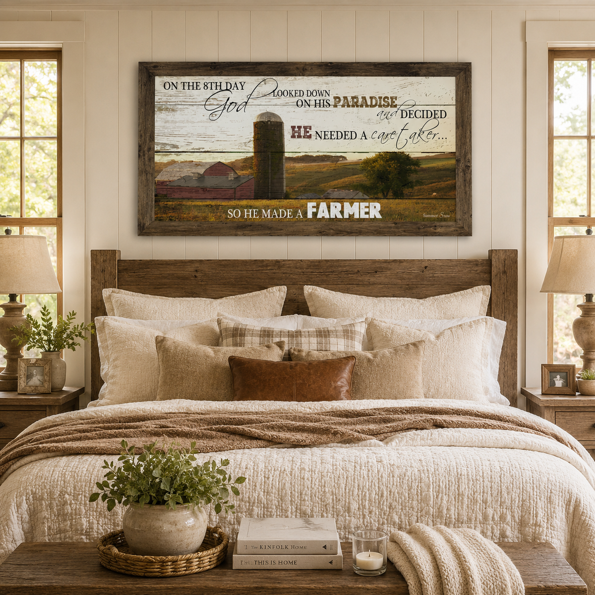 Natural brown framed wide panoramic farmhouse wall art featuring the full On The 8th Day God Made A Farmer quote with red barn and silo displayed as a large 40x20 statement piece above a reclaimed wood headboard in a cozy farmhouse master bedroom with white quilt and plaid pillows