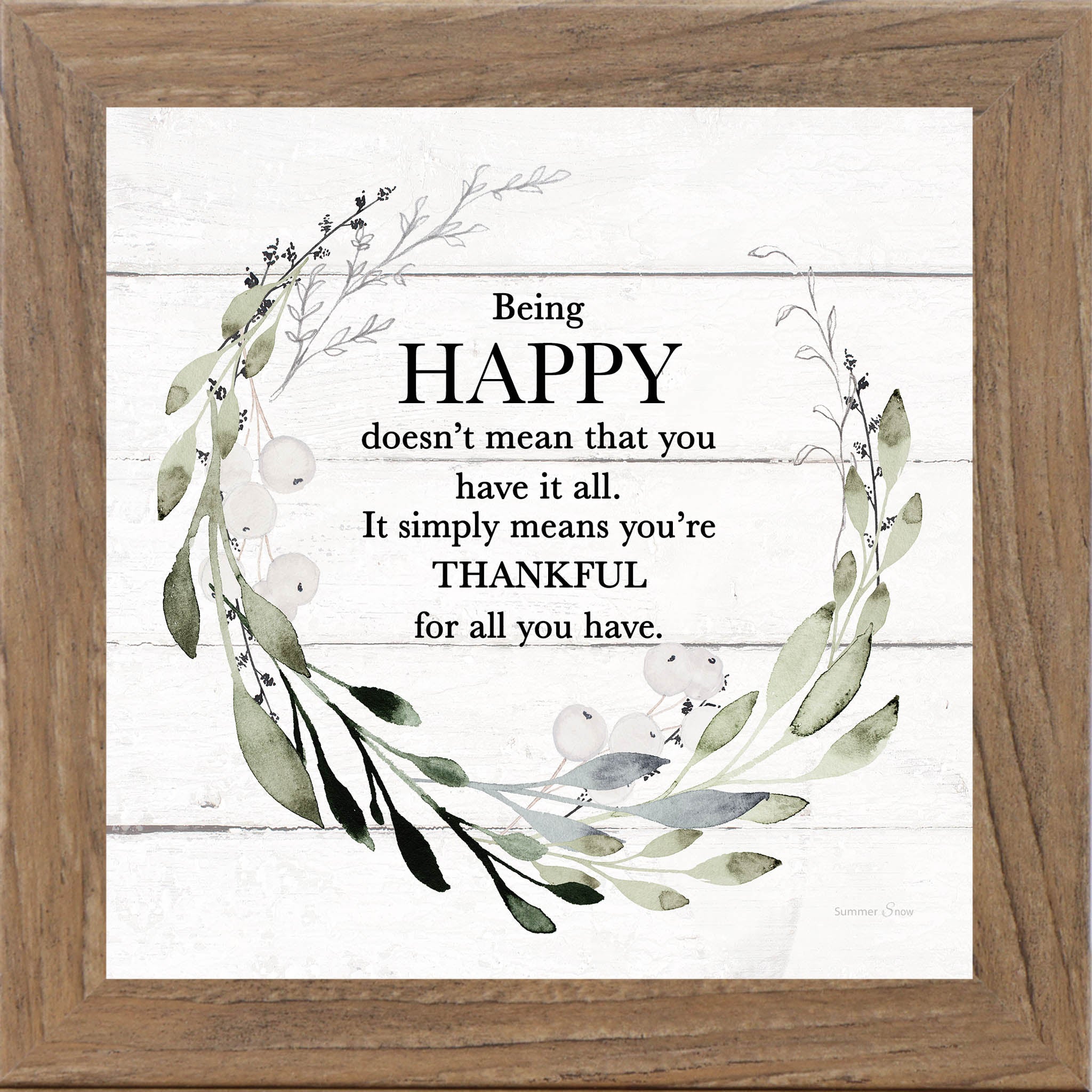 Framed inspirational wall art with the quote Being Happy doesn’t mean that you have it all, surrounded by green leafy florals on a white slatted wood background