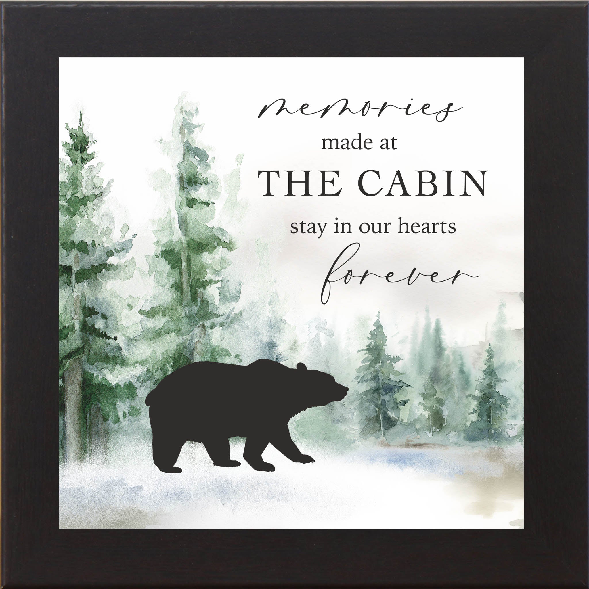 Framed cabin wall art with the quote “Memories made at the cabin stay in our hearts forever,” featuring a watercolor evergreen forest and a bear illustration in the foreground.