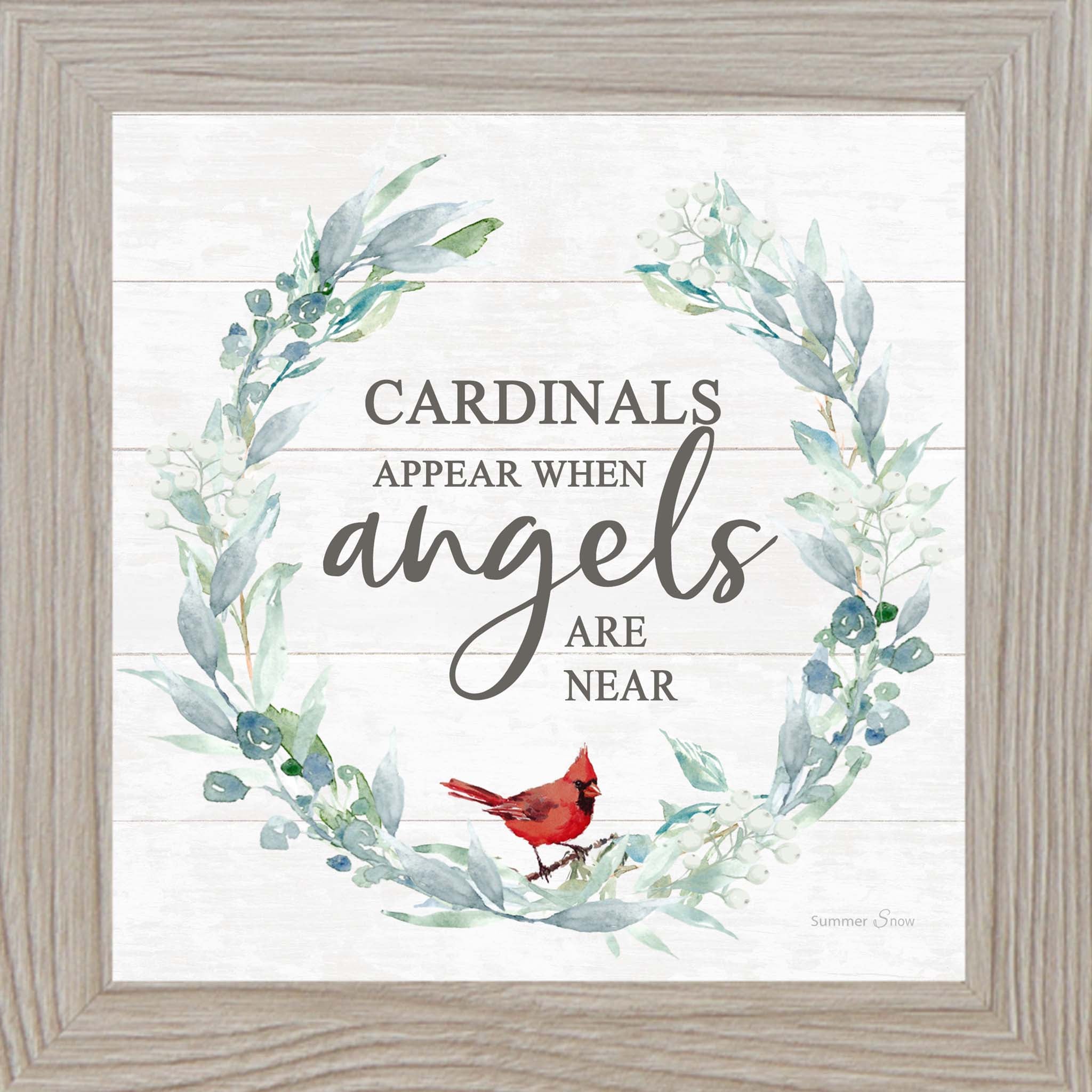 Square framed wall art featuring the phrase “Cardinals appear when angels are near” with a green floral wreath and red cardinal on a white slatted wood background