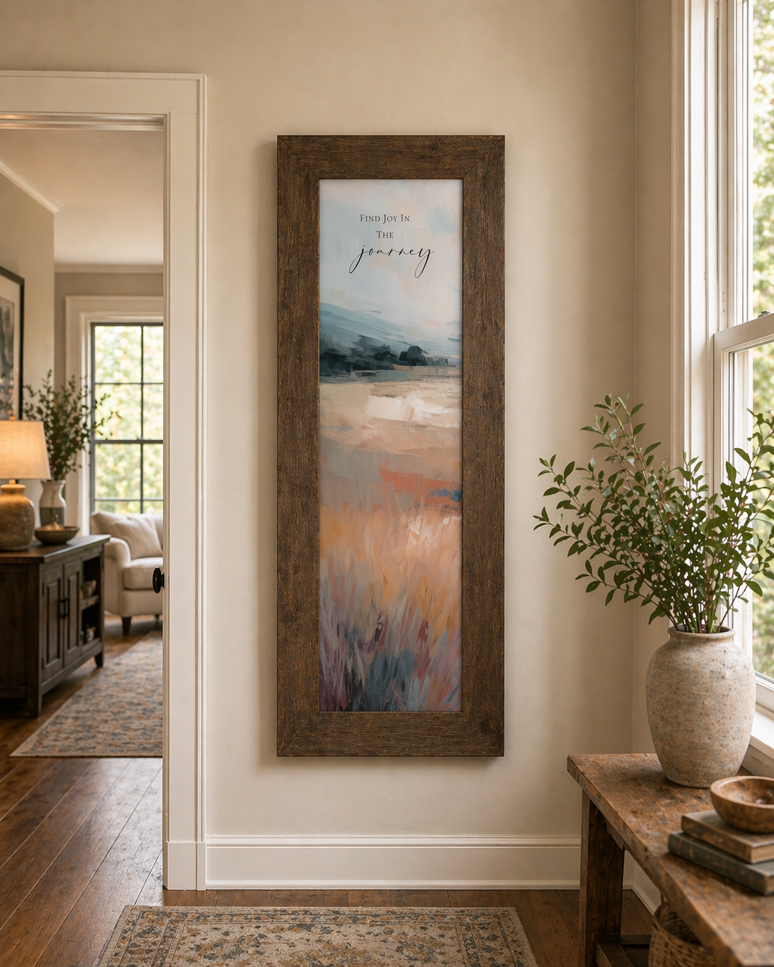 Entryway with Natural Brown framed narrow portrait inspirational wall art with Find Joy In The Journey quote over a terracotta abstract landscape with soft blue-grey sky and warm amber field with burgundy foreground grasses