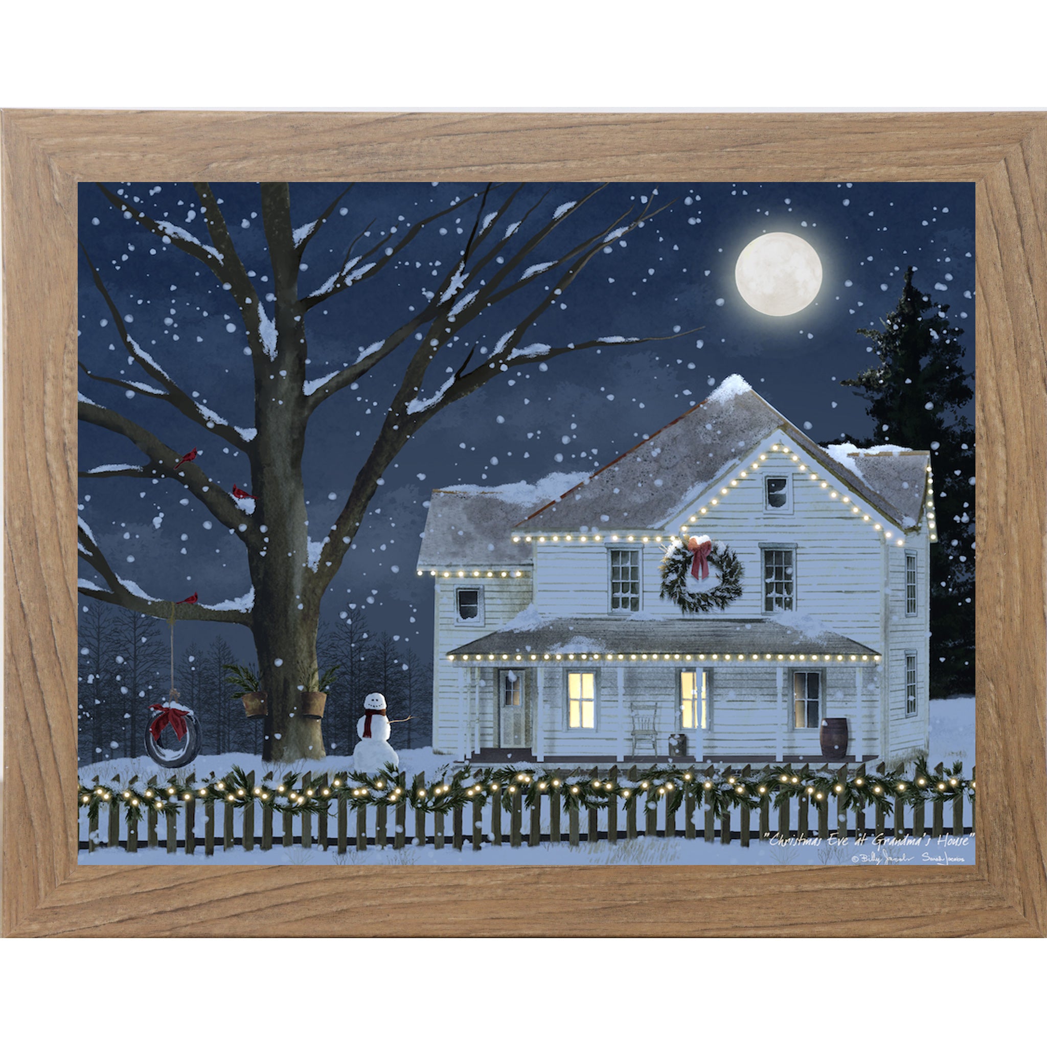 Farmtable framed Billy Jacobs Christmas Eve at Grandma's House wall art featuring a glowing white farmhouse with string lights wreath and snowman under a full moon in a midnight blue snowy sky with cardinals in a bare tree