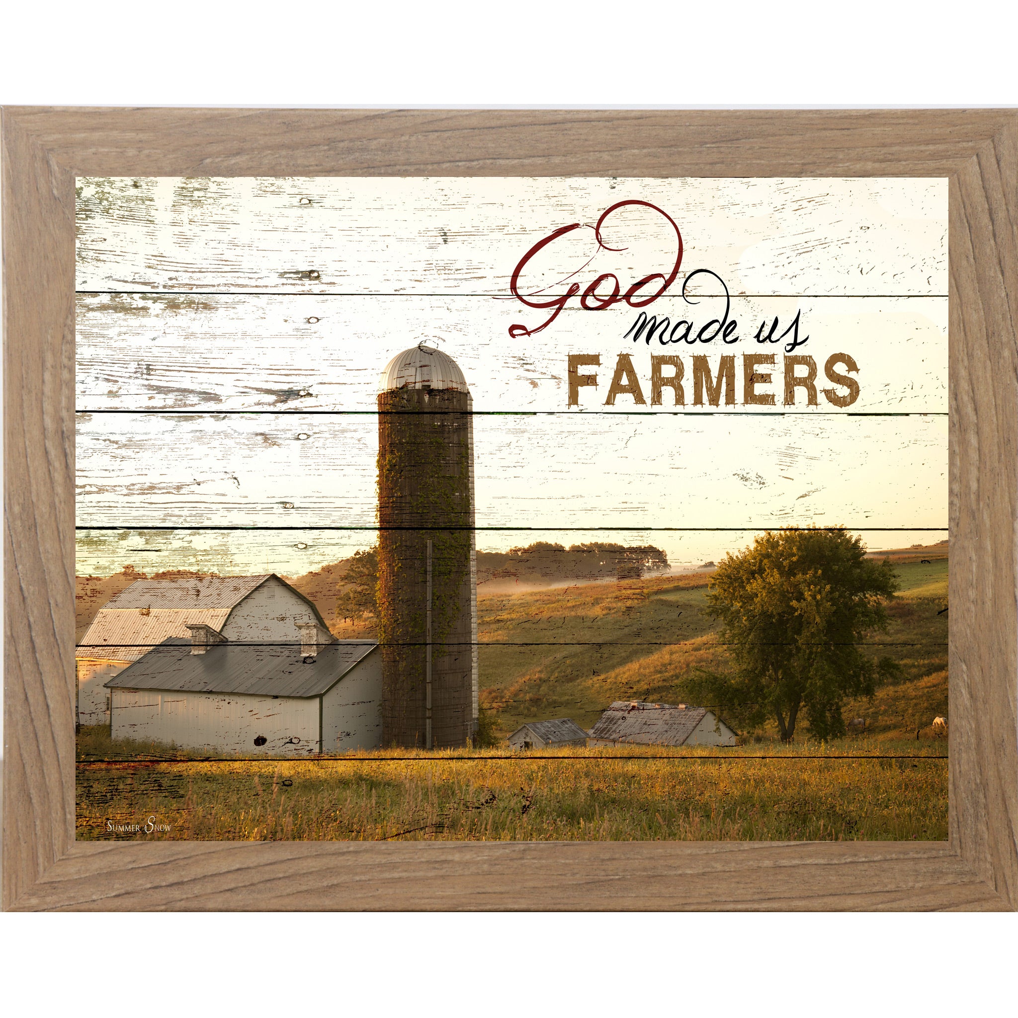 Farmtable framed horizontal farmhouse landscape wall art featuring a white barn and silo on rolling green hills with pallet wood background and the words God Made Us Farmers
