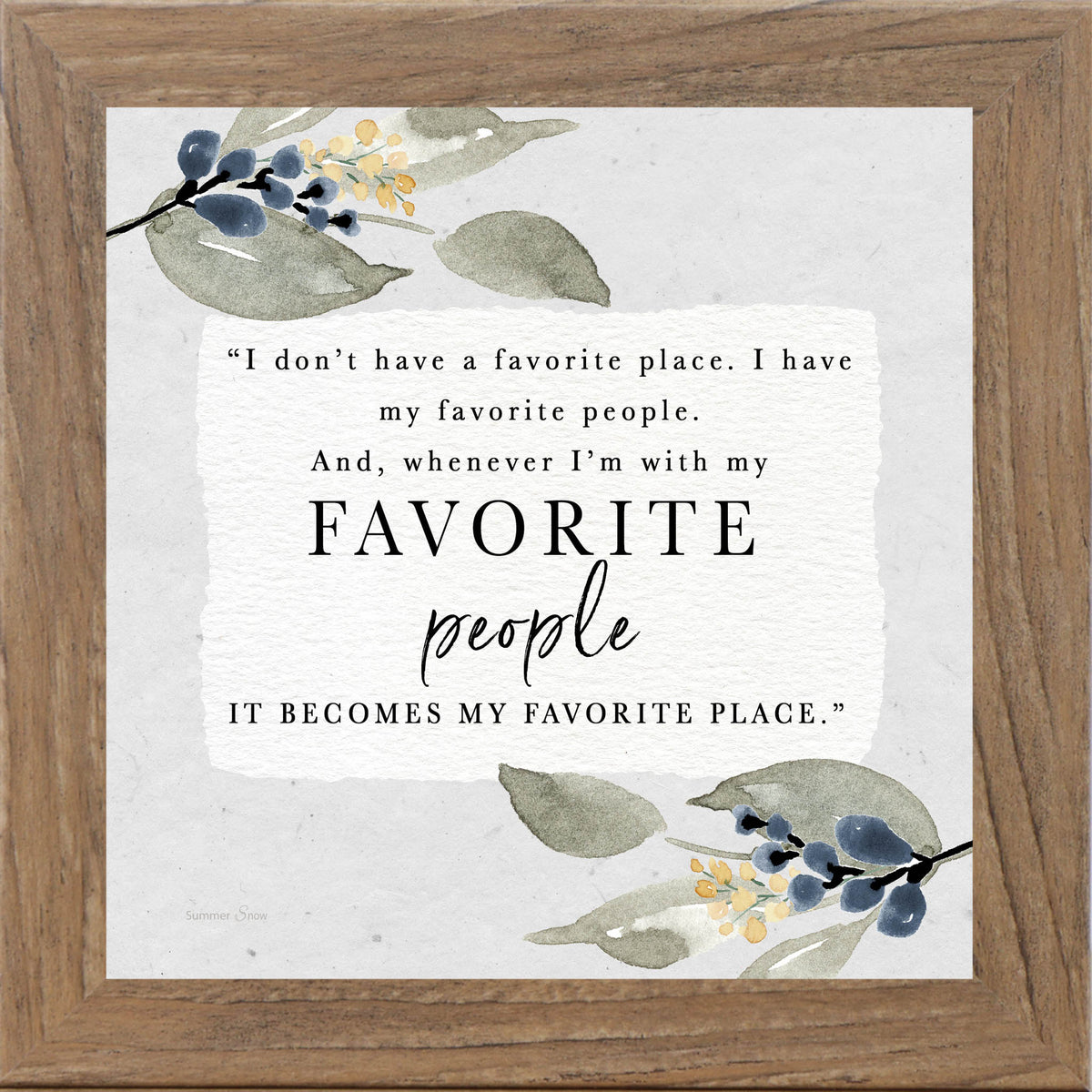 Framed inspirational wall art with the quote “I don’t have a favorite place, I have my favorite people,” featuring soft green leaves with subtle blue and yellow blooms on a neutral background.