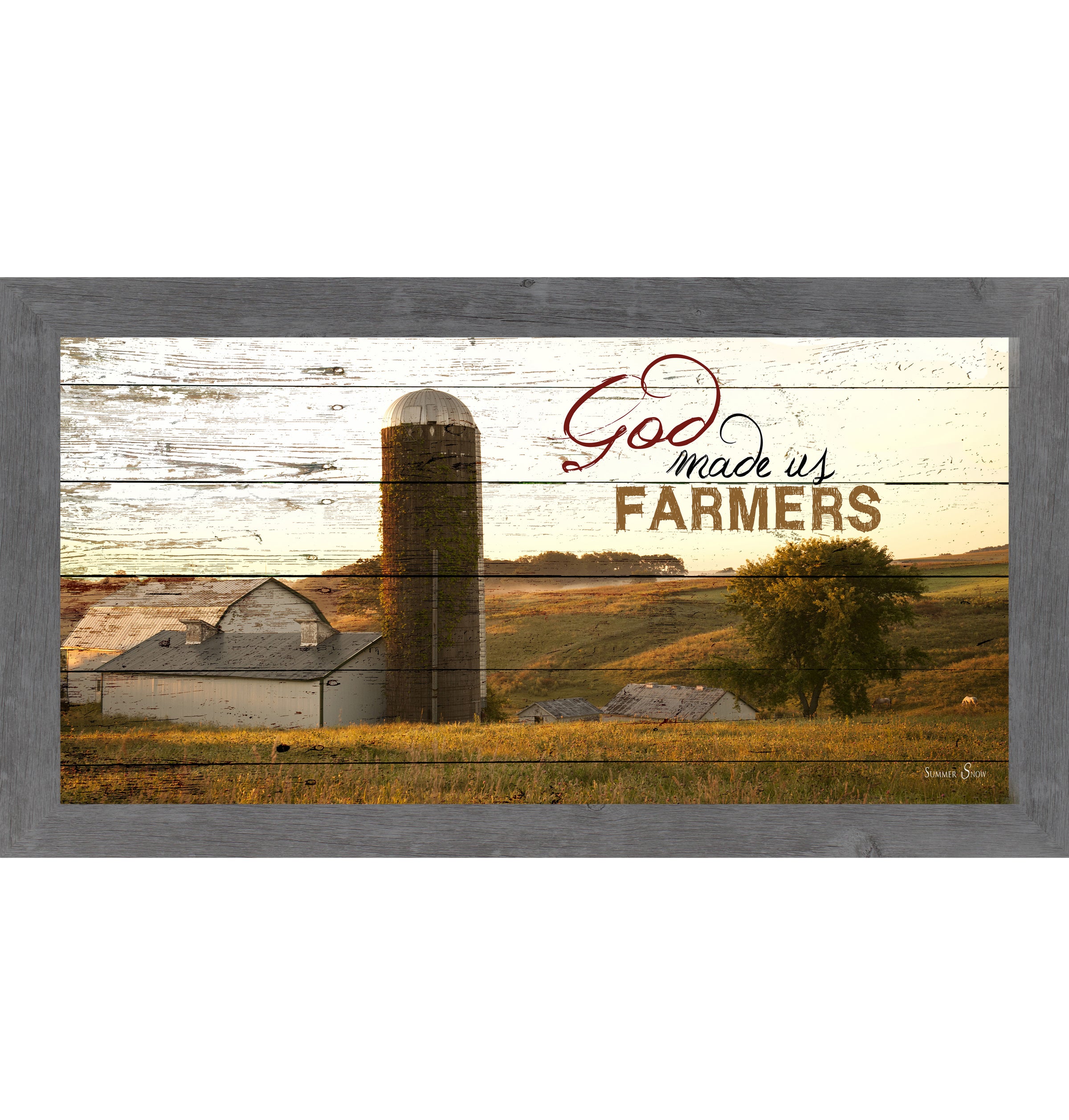 Gray framed wide panoramic farmhouse wall art featuring a white barn and silo on rolling golden hills with pallet wood background and the words God Made Us Farmers