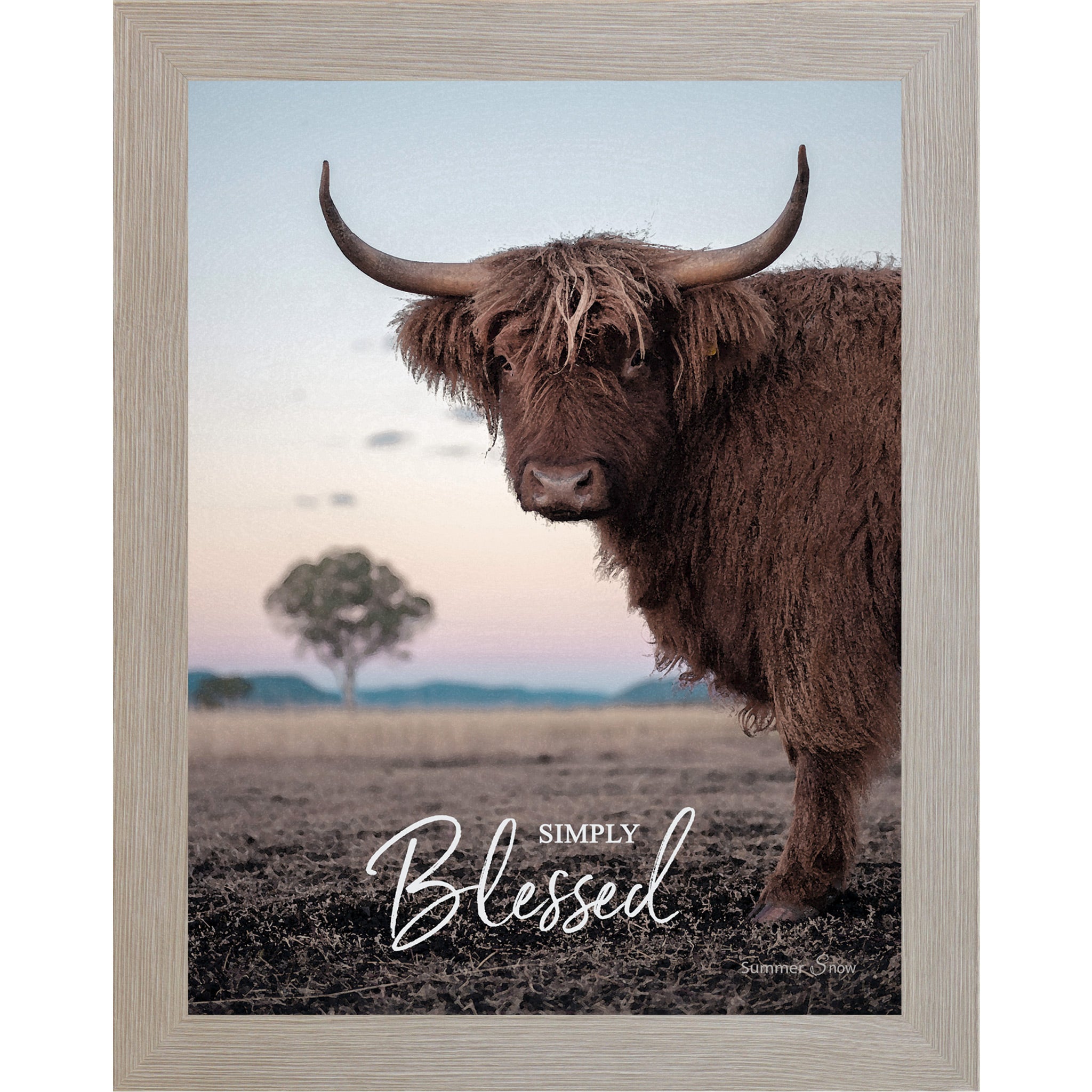 Monte Carlo framed vertical farmhouse portrait wall art featuring a Highland cow with curved horns standing in a twilight field with a soft blush sky and lone tree with the words Simply Blessed