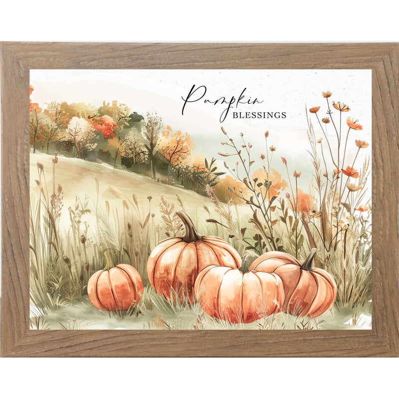 Framed fall art print with orange pumpkins in a green field, orange flowers, and colorful autumn trees in the background. Titled “Pumpkin Blessings.”