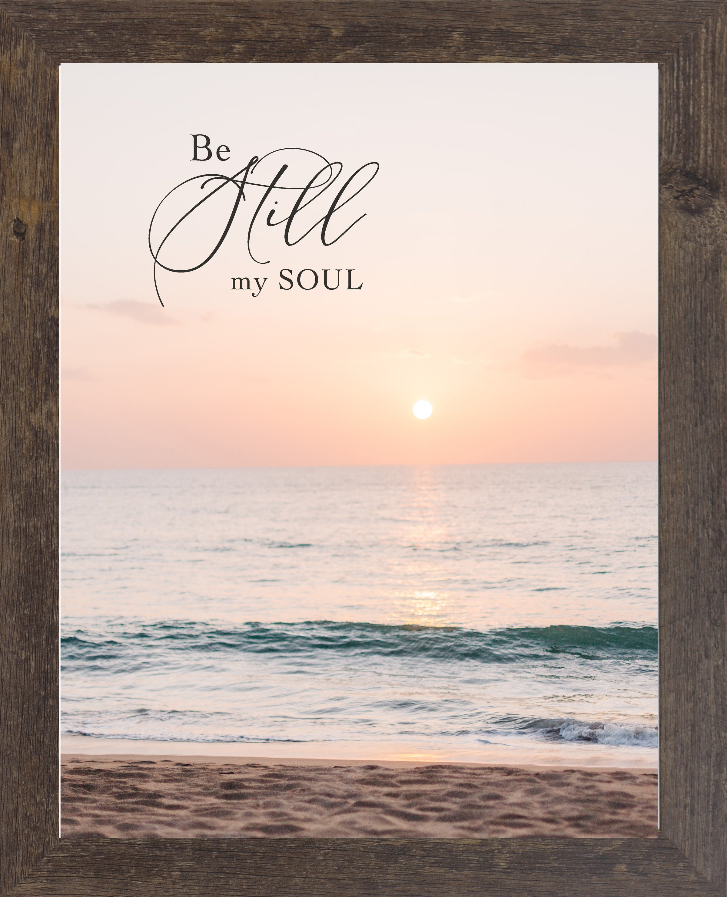 Natural brown framed portrait Christian wall art with the words Be Still My Soul in elegant script set against a soft peach and coral beach sunset with teal ocean waves and sandy shoreline
