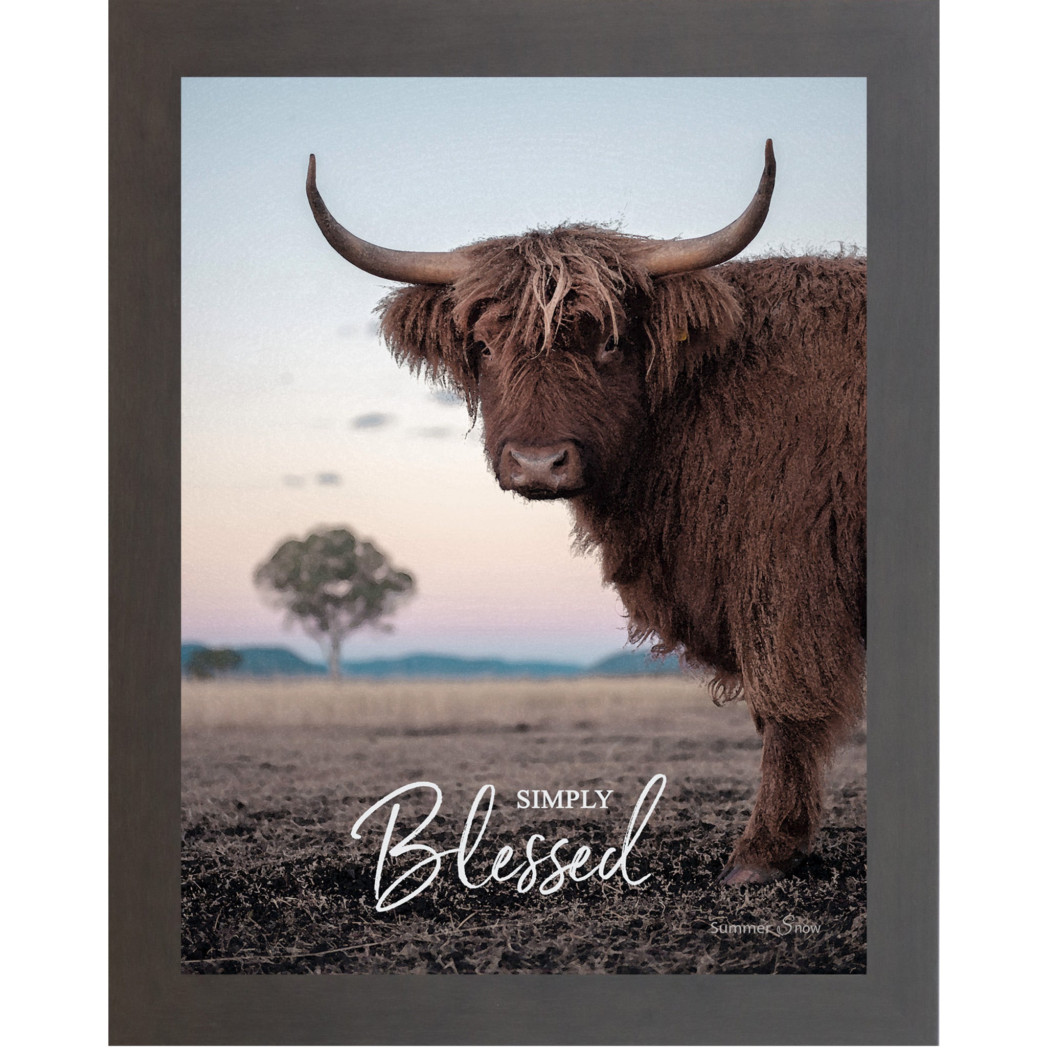 Slatewood framed vertical farmhouse portrait wall art featuring a Highland cow with curved horns standing in a twilight field with a soft blush sky and lone tree with the words Simply Blessed