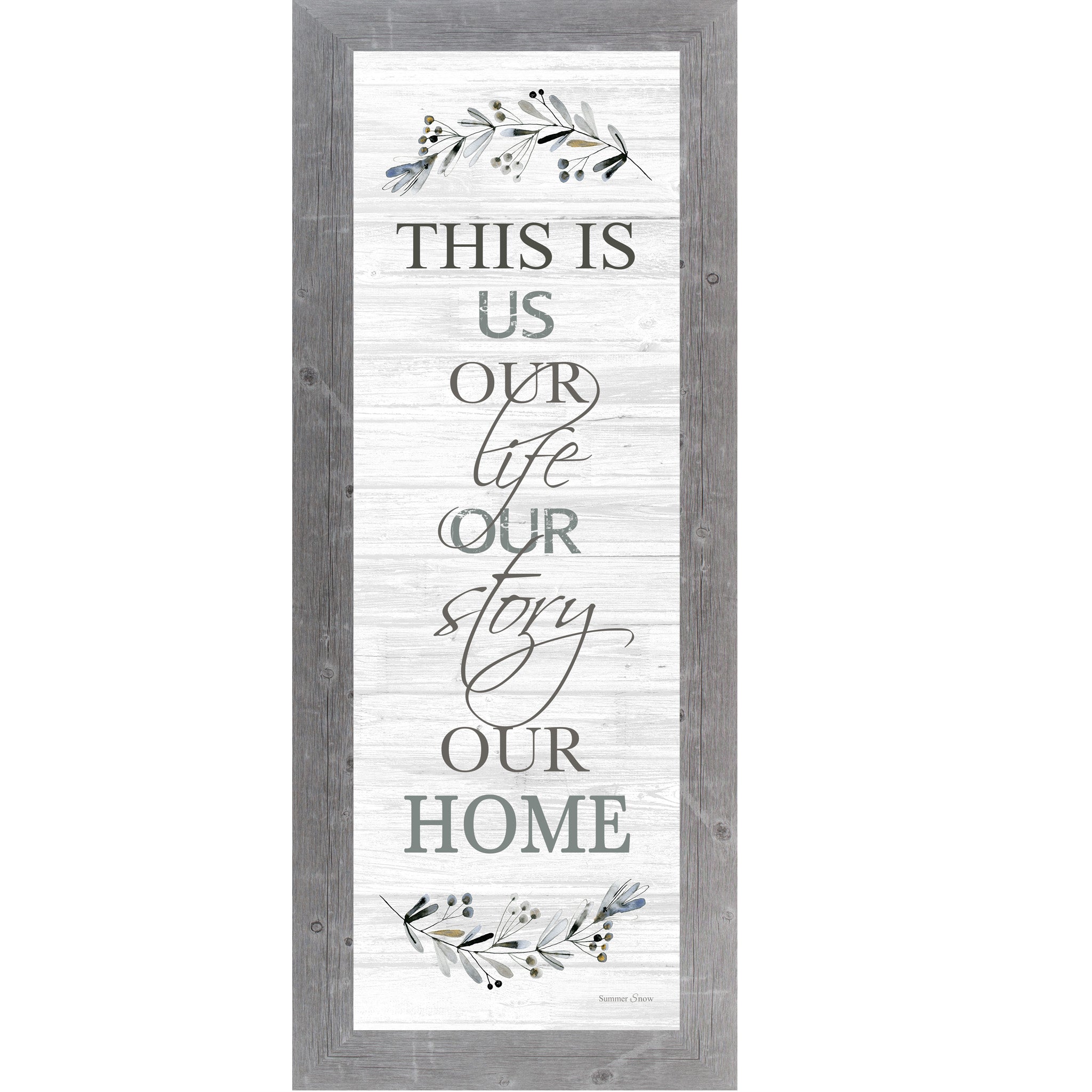 Vertical framed wall art with the phrase This Is Us Our Life Our Story Our Home on a white slatted wood background with blue floral accents