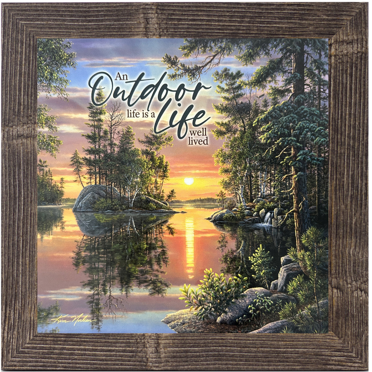 Framed 8x8 lake and sunset wall art by Kim Norlien. Quiet wooded cove with reflection, sunset sky, and the words “An Outdoor Life Is a Life Well Lived.”