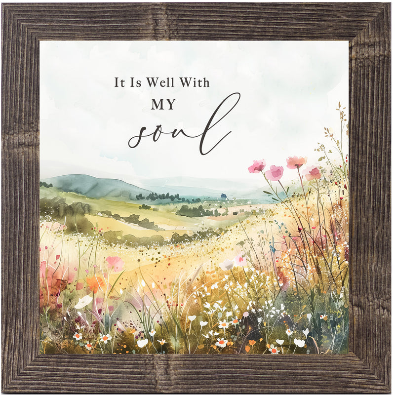 Framed Christian wall art with the quote “It Is Well With My Soul.” Watercolor hills, pink and white spring flowers, soft green landscape.