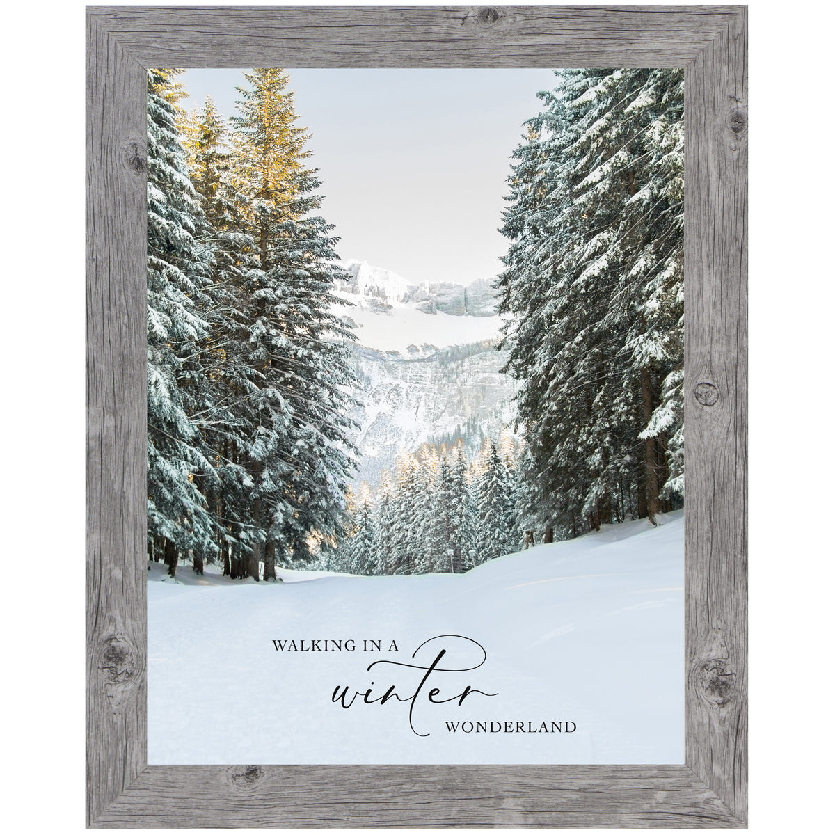 Framed winter wall art with snowy evergreen trees, wide forest path, distant mountains, and the quote “Walking in a Winter Wonderland”
